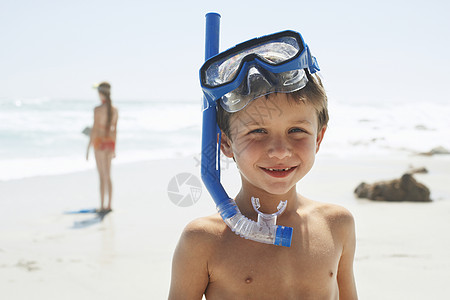 站在沙滩上时穿着潜水衣的可爱小男孩的肖像图片