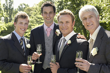 喜庆那天四位男人拿着香槟笛子 欢乐快乐的肖像图片