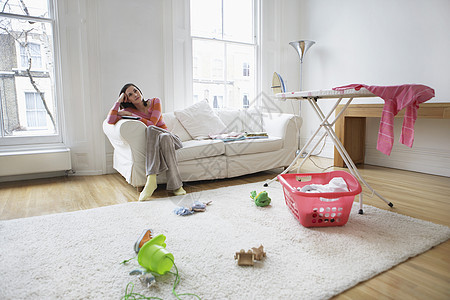 一个疲累的家庭主妇在家沙发上放松的完整肖像图片