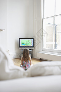 一个小小女孩在家里电视上看漫画的近视 家庭主播图片