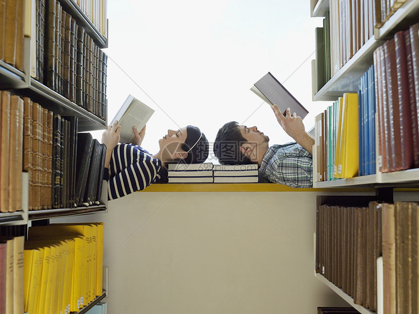 男学生和女学生在图书馆阅读中趴在窗台上图片