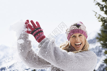 一位快乐的年轻女子捕雪球的肖像图片