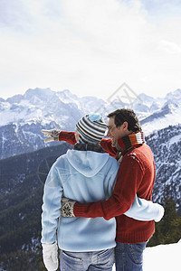 一对夫妇从山峰看景色的近视假期男性女士娱乐分发手势天空团结衣服女性图片
