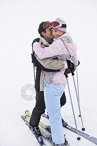 在滑雪坡上站着滑雪滑雪的情侣图片