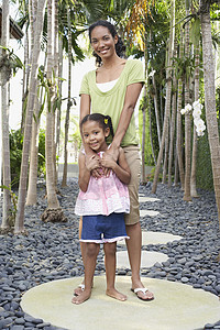 整个母亲在踏脚石上与女儿肩膀围着女儿站在一起图片