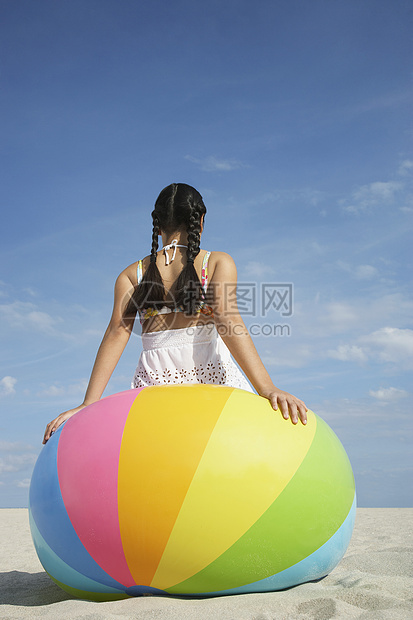 坐在大沙滩球上的少女的近视图片