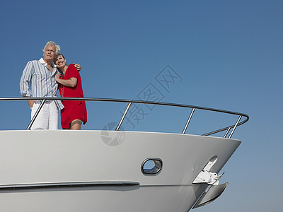 持手站在游艇弓上 与蓝天对立的浪漫中年夫妇图片