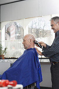在理发厅用电剃刀剃了老人头部的剃须刀图片