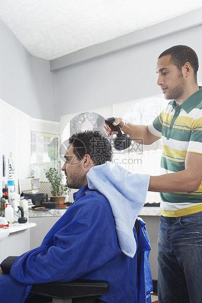 年轻理发师 让男人在理发店理发图片