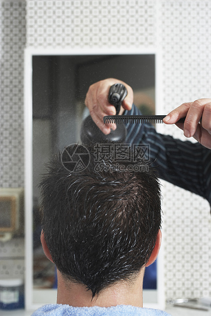 理发店的理发师喷洒男子头发图片