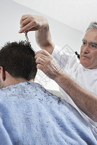 在理发店剪人头发的高级理发师剪刀发型师男士发型设计顾客男性职业沙龙理发发型图片