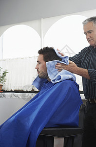 高级理发师在理发店用毛巾洗头发图片