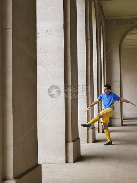 足球运动员在Portico踢球的全长柱子制服球衣成人运动服男性男人训练城市门廊图片