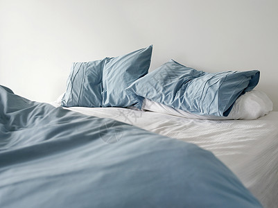清晨看无缝床的景象 床上有折叠蓝床单 没有人图片