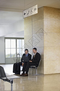 在机场大厅使用膝上型电脑的两名商务人士笔记本椅子男性男士成人沟通行李讨论办公室手提箱图片