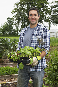 一个带着田地植物的微笑的男人的肖像图片