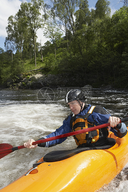 年轻男子在河里划皮艇的景象白水夹克危险橙子享受运动爱好行动挑战娱乐图片