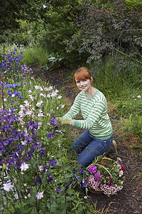 一位在花园采花的年轻女子的侧面肖像图片