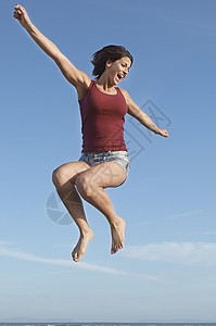 中空中延伸的中成年妇女中途跳臂图片