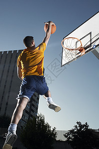 有篮球的年轻人 跳向中空圈图片