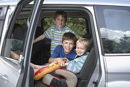 车上三个微笑男孩的肖像团结男生兄弟座椅水平运输车辆汽车闲暇座位图片
