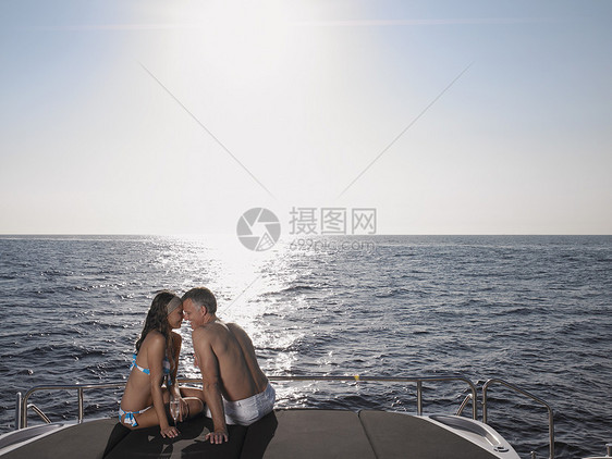 浪漫夫妇在坐在游艇的海边上摩擦鼻子图片