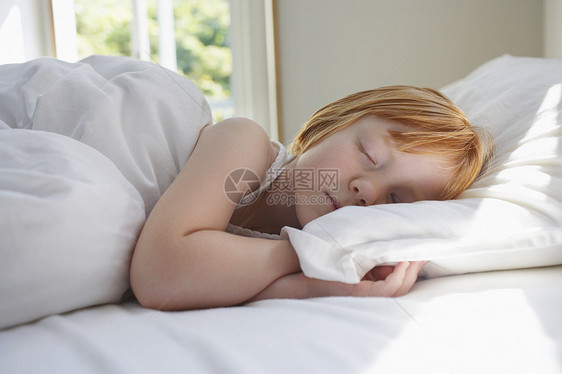 可爱的小女孩睡在家里床上睡觉图片