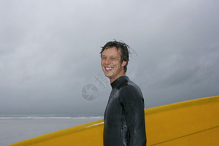 冲浪船在海滩肖像侧视图上携带冲浪板露齿成年海洋一人娱乐大海潜水快乐短发头发图片