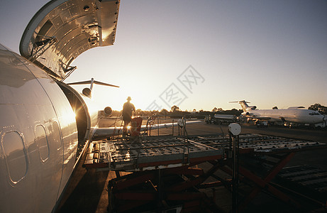 向波音727喷气式飞机装载货运日落运输飞机场货物阳光货舱图片