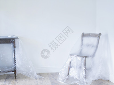 空房间里用塑料遮盖的椅子和桌子图片