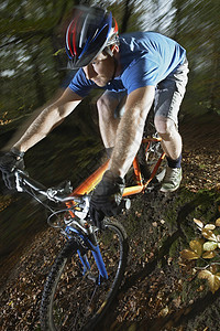 年轻男子在森林中骑着山上自行车的模糊运动男人运输活动骑术森林娱乐男士冒险山地活力图片