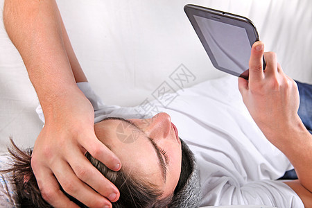 配有平板电脑的年轻人工具流感沙发互联网男性阅读被单枕头药片男人图片