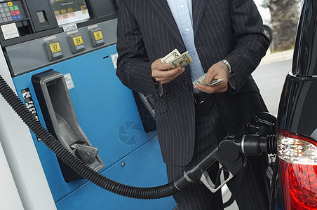 在车站加油汽车时数钱的生意人中间一小段高清图片