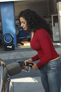 美女的侧面景色 在车站把煤气泵进车里图片