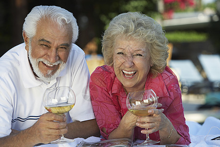 快乐的老年情侣的肖像 在花园里放酒杯放松图片
