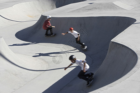 3名少年男孩(16-17岁)在滑冰公园高风景上滑板图片