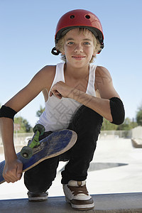 青少年男孩的全长画像 滑板在溜冰公园中蹲着图片