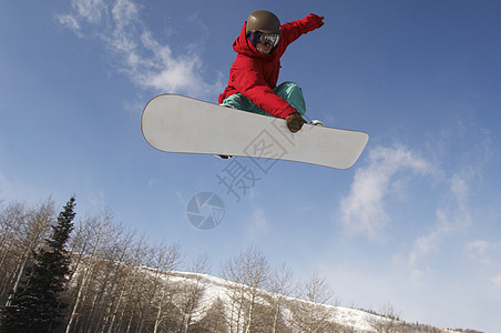 年轻男性滑雪运动员跳过天空的低角度视图图片