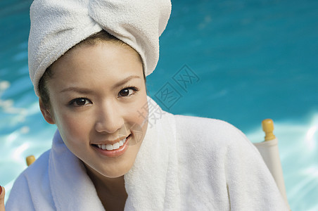 泳池旁浴袍中美女的肖像图片