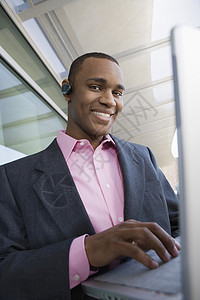 一位在笔记本电脑上工作的非洲裔美国商务人士的快乐景象图片
