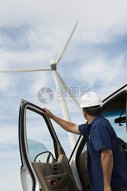风力农场一名男工程师乘汽车低角度视角图片