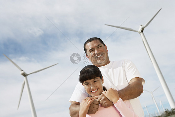 快乐父亲在风力农场拥抱女儿的低角度视角图片