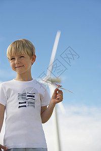 在风车农场玩玩具滑翔机的小可爱男孩图片