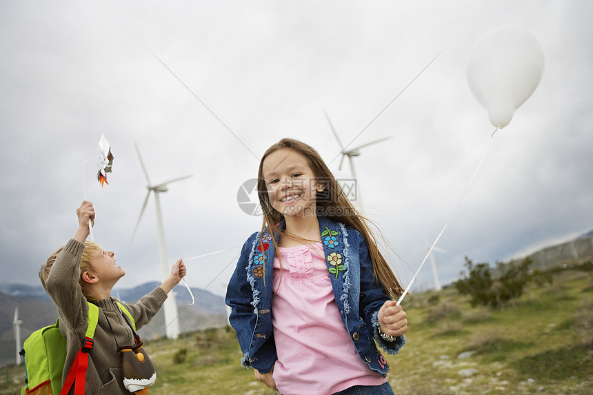 在风力农场玩气球的男女小男孩女孩图片