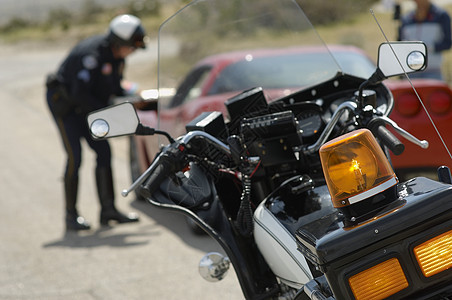 摩托车与交通警和车背景背景的汽车紧闭图片