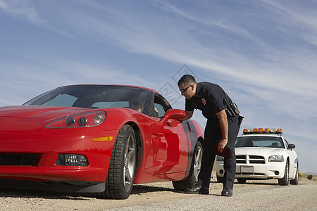 交通警察与男子讨论红色运动车的驾驶员问题图片