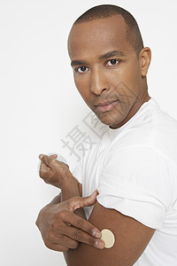 一名非洲裔美国人的肖像 其手臂上有尼古丁补丁 白色背景与他隔绝图片