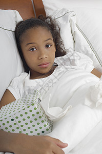 一个在床上放纸箱的非裔美国女孩的肖像图片