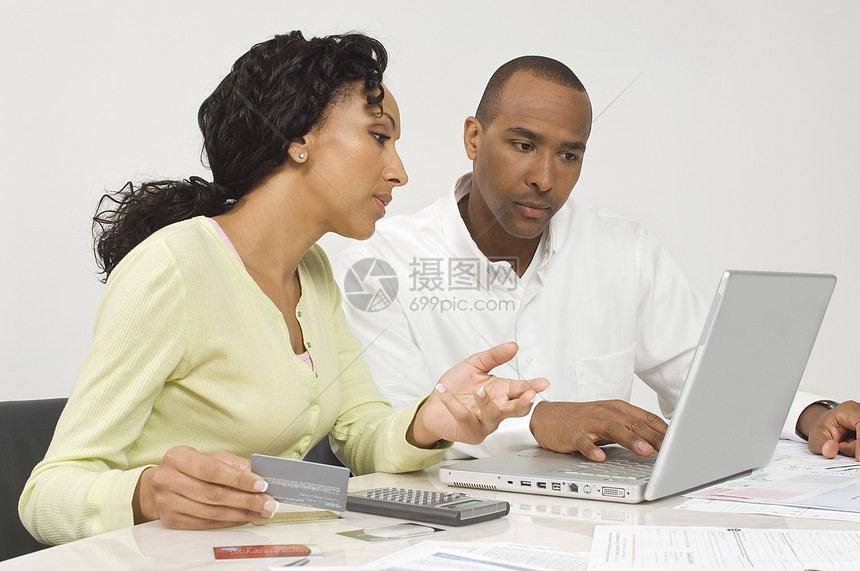 一对非裔美国人夫妇在笔记本电脑上寻找财务图片