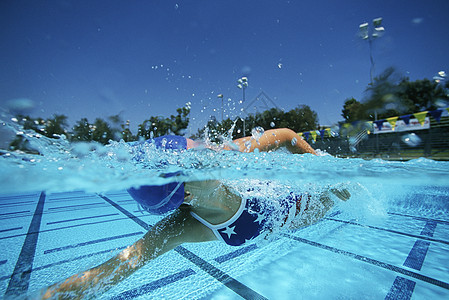 年轻的高加索女性游泳运动员在游泳池游泳图片